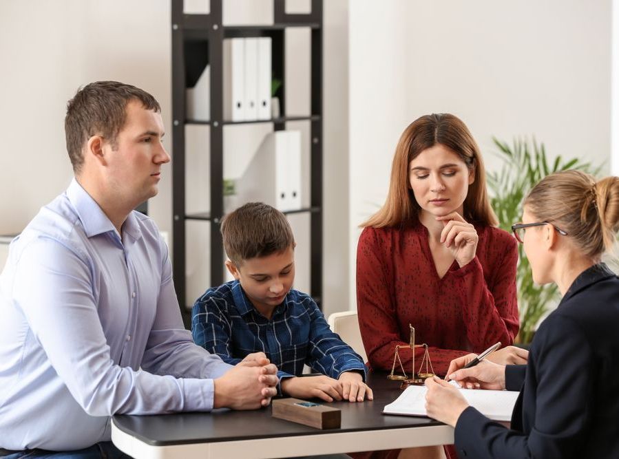 A Family Is Sitting At A Table Talking To A Lawyer — Charlestown Law Firm In Charlestown, NSW