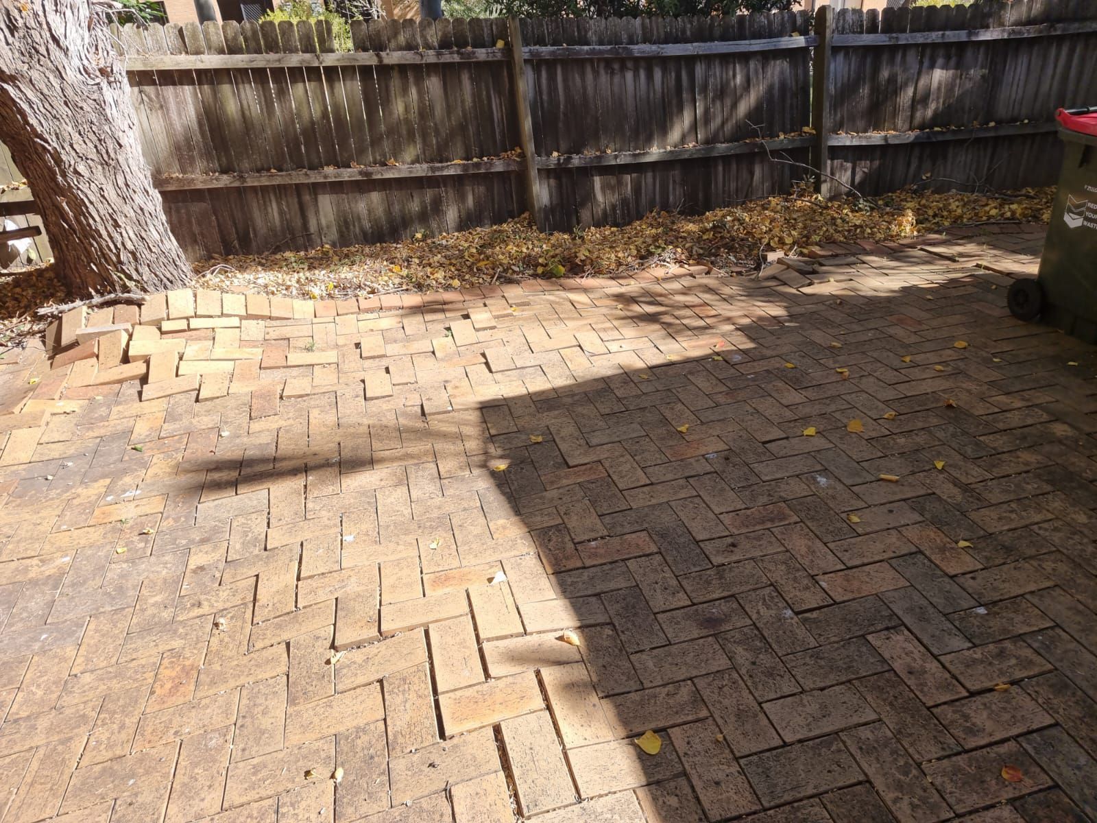 A brick patio with a wooden fence in the background