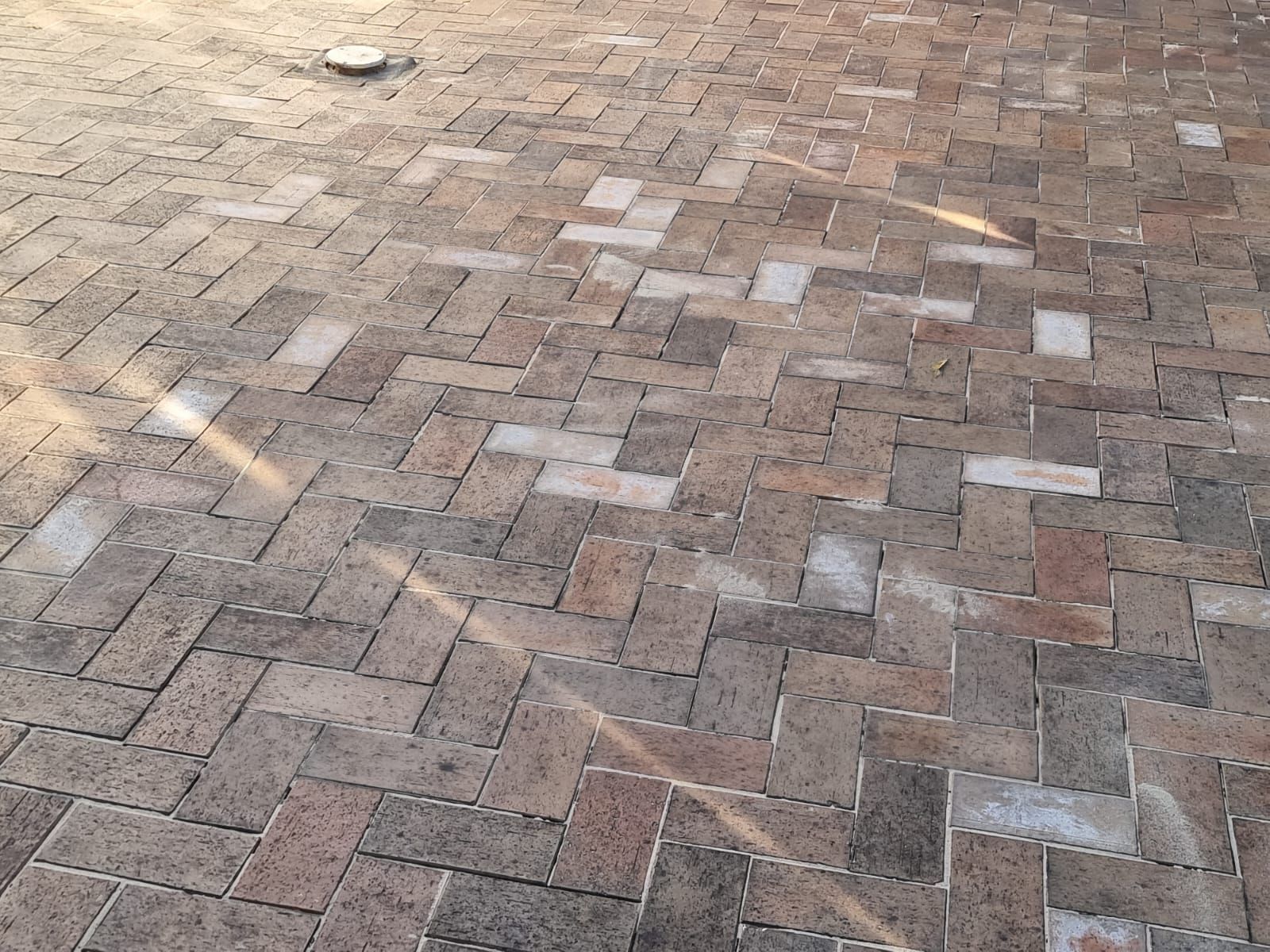 A close up of a brick driveway with a herringbone pattern.