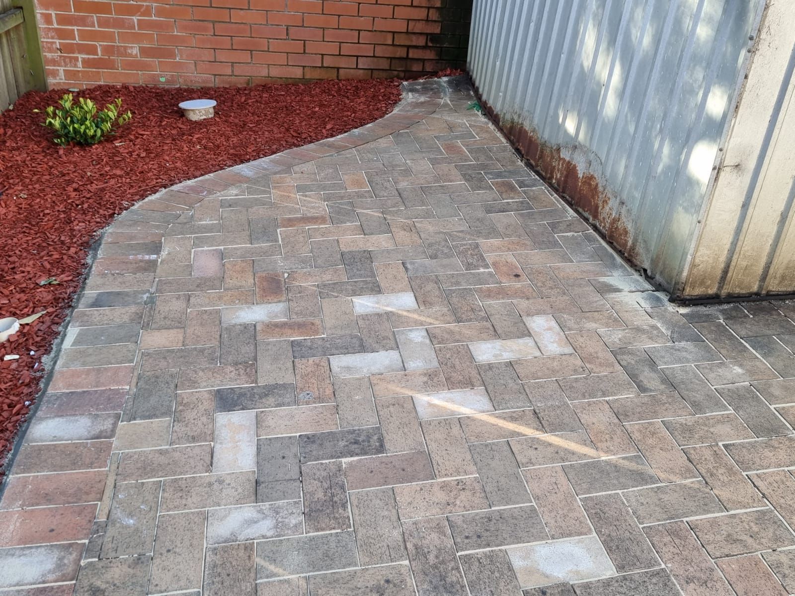 A brick walkway with a brick wall in the background