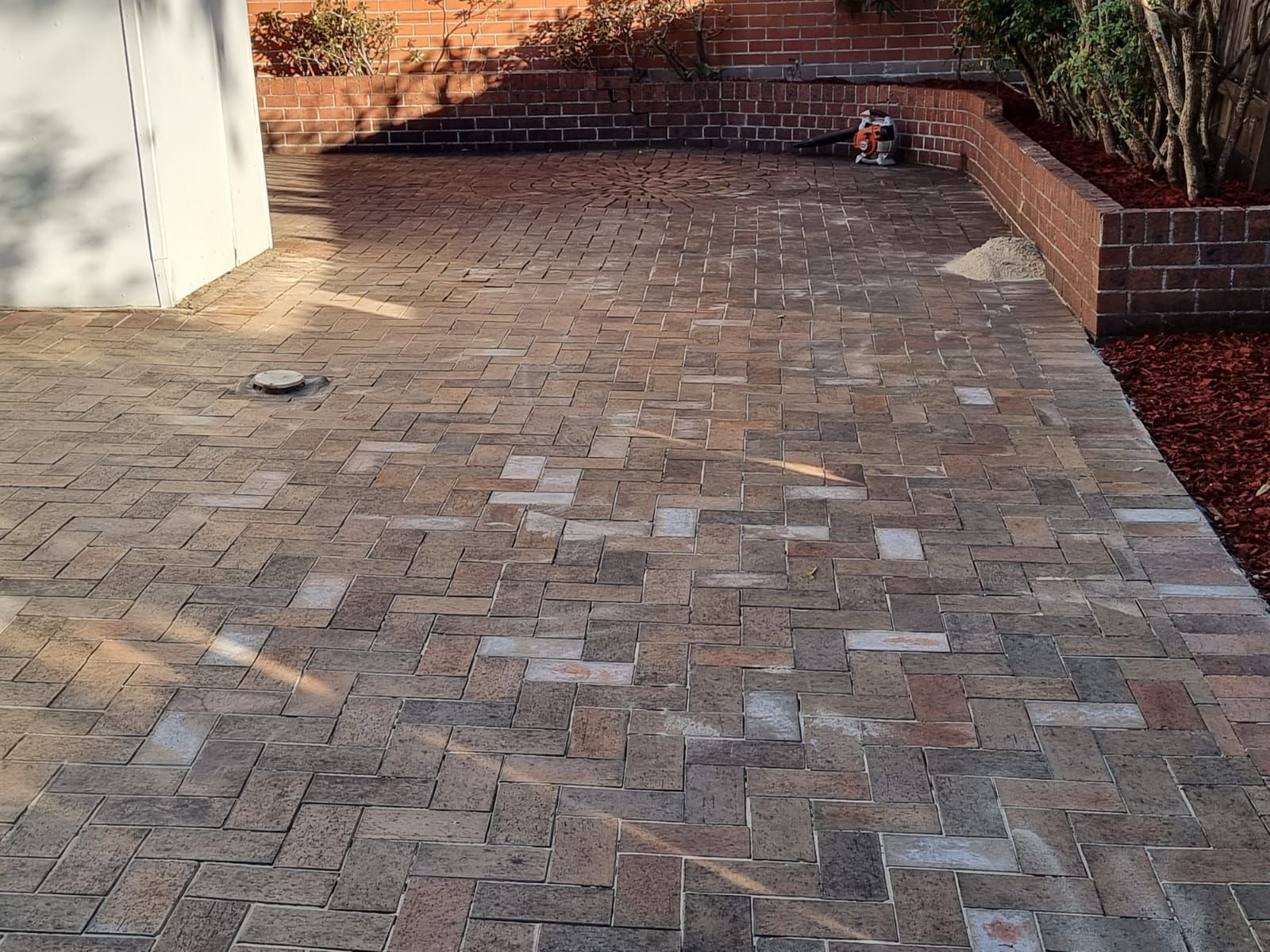 A brick driveway with a brick wall in the background