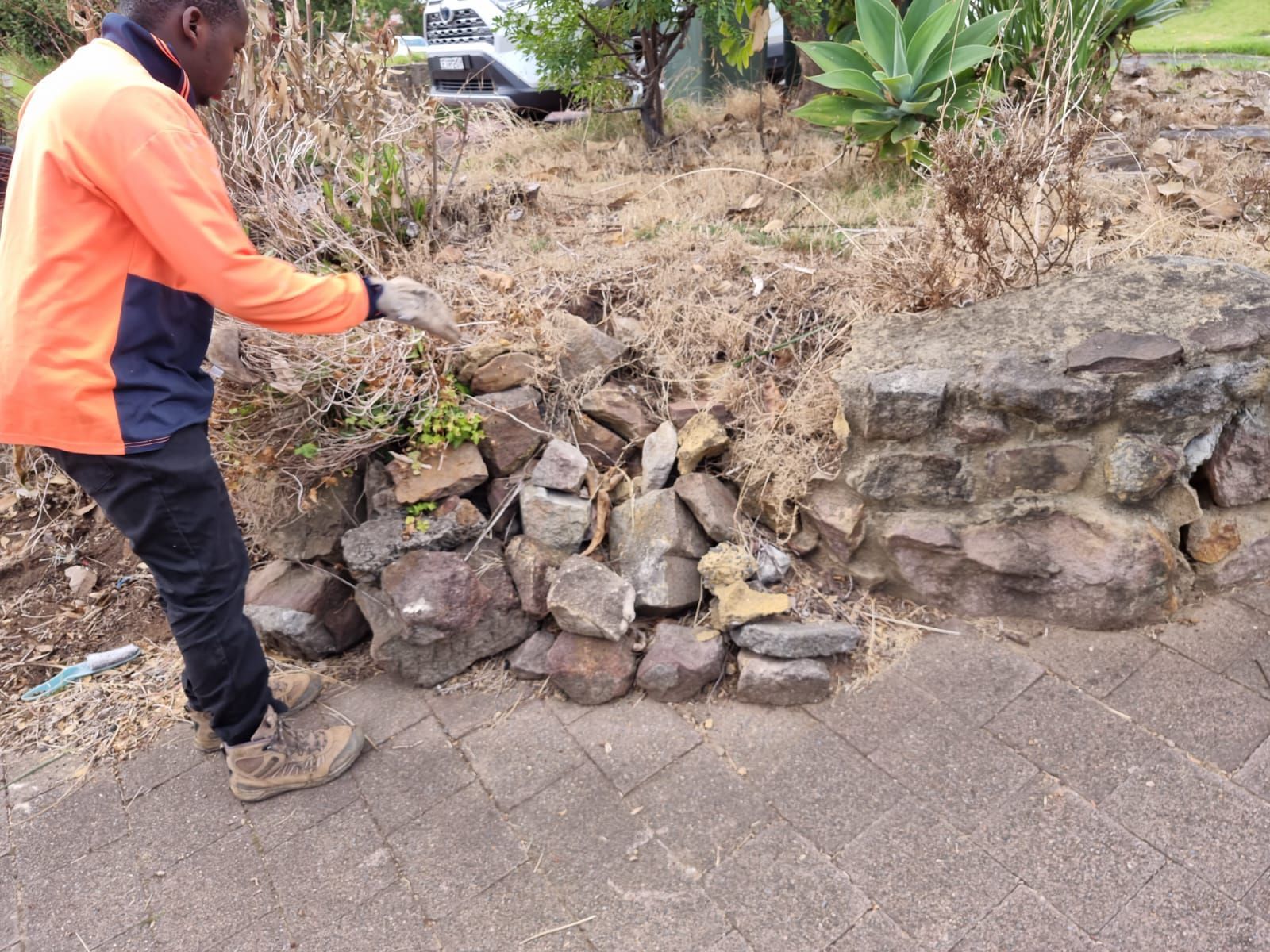 A man is standing next to a pile of rocks.