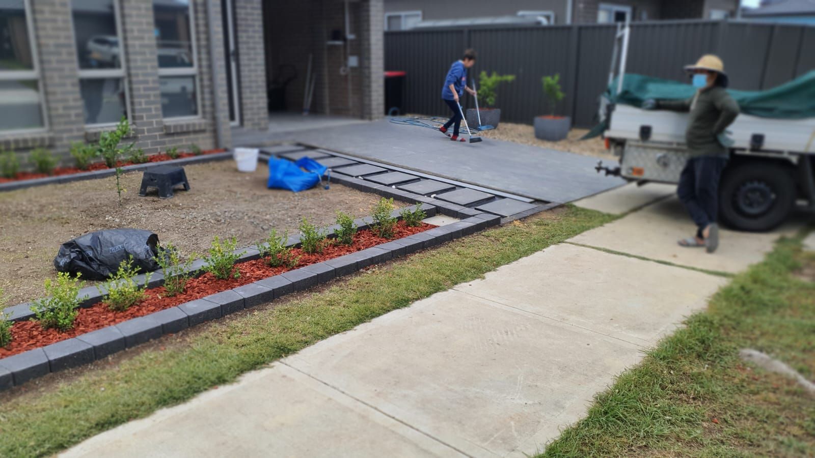 A man is standing next to a truck in front of a house.