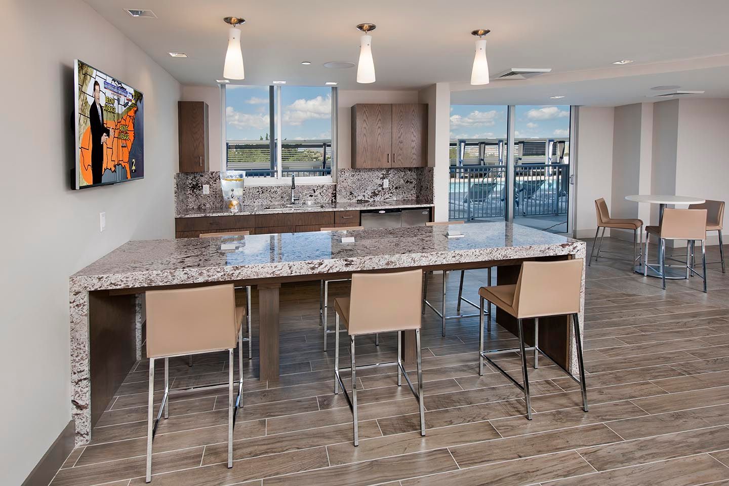 Kitchen and seating area with a granite countertop and a view. Three bar stools are present.
