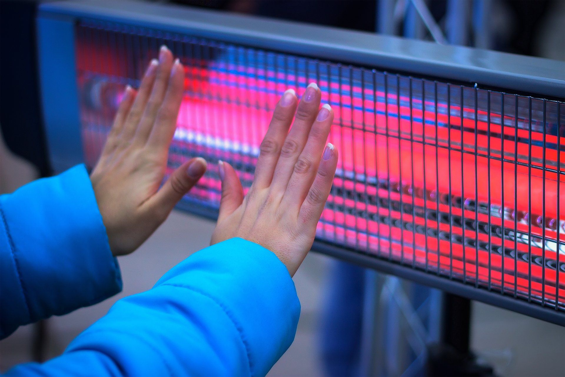 Girl Hands Warming With Heating Radiator at evening winter outdoor