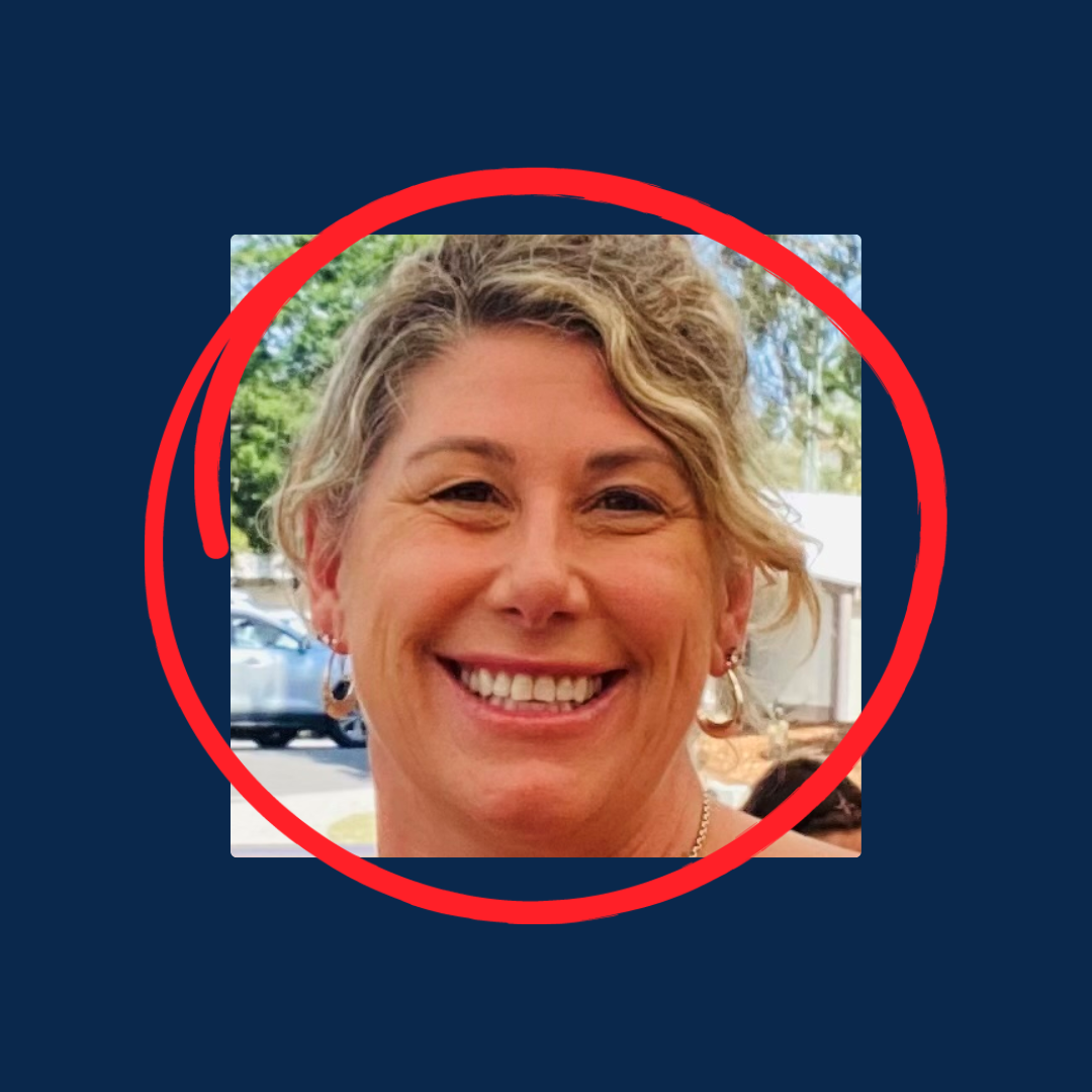 A person with blonde, curly hair smiling broadly, shown in a headshot framed by a red circle against a dark blue background.