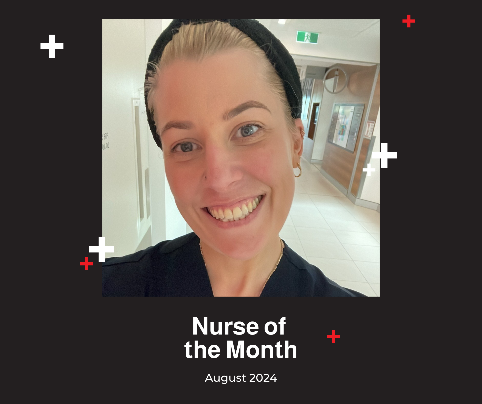 A nurse is smiling for the camera in a hospital hallway.