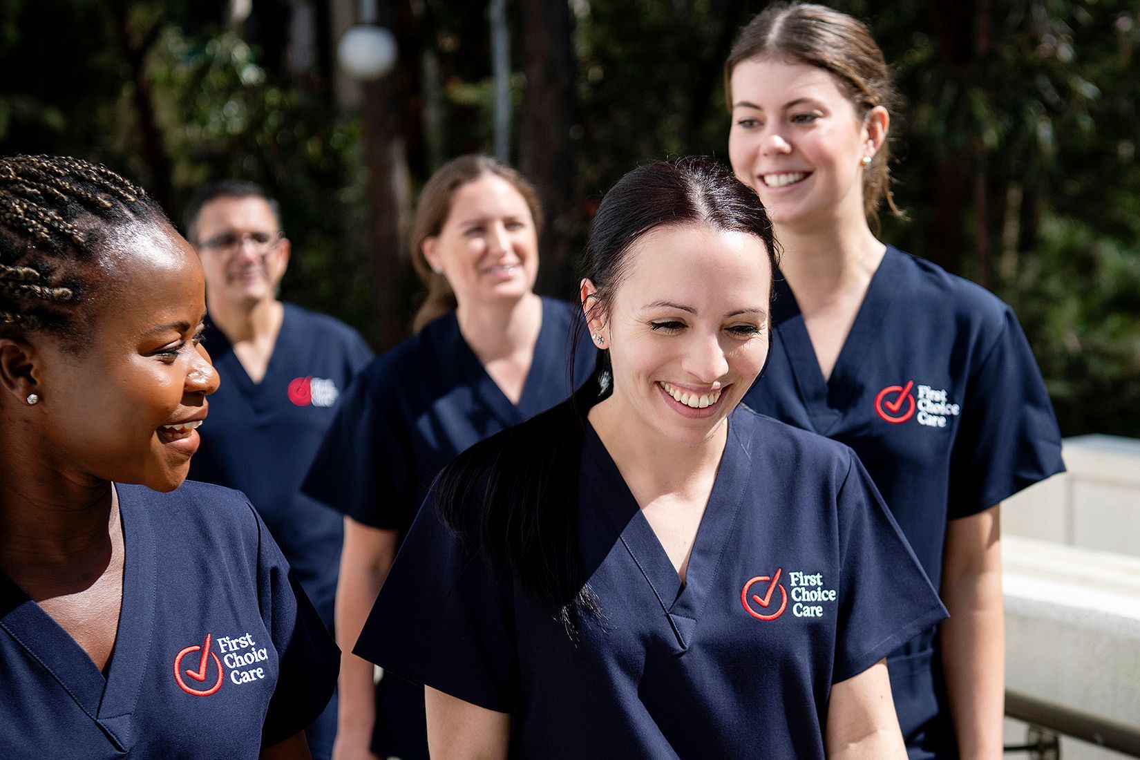 A group of nurses are standing next to each other and smiling.