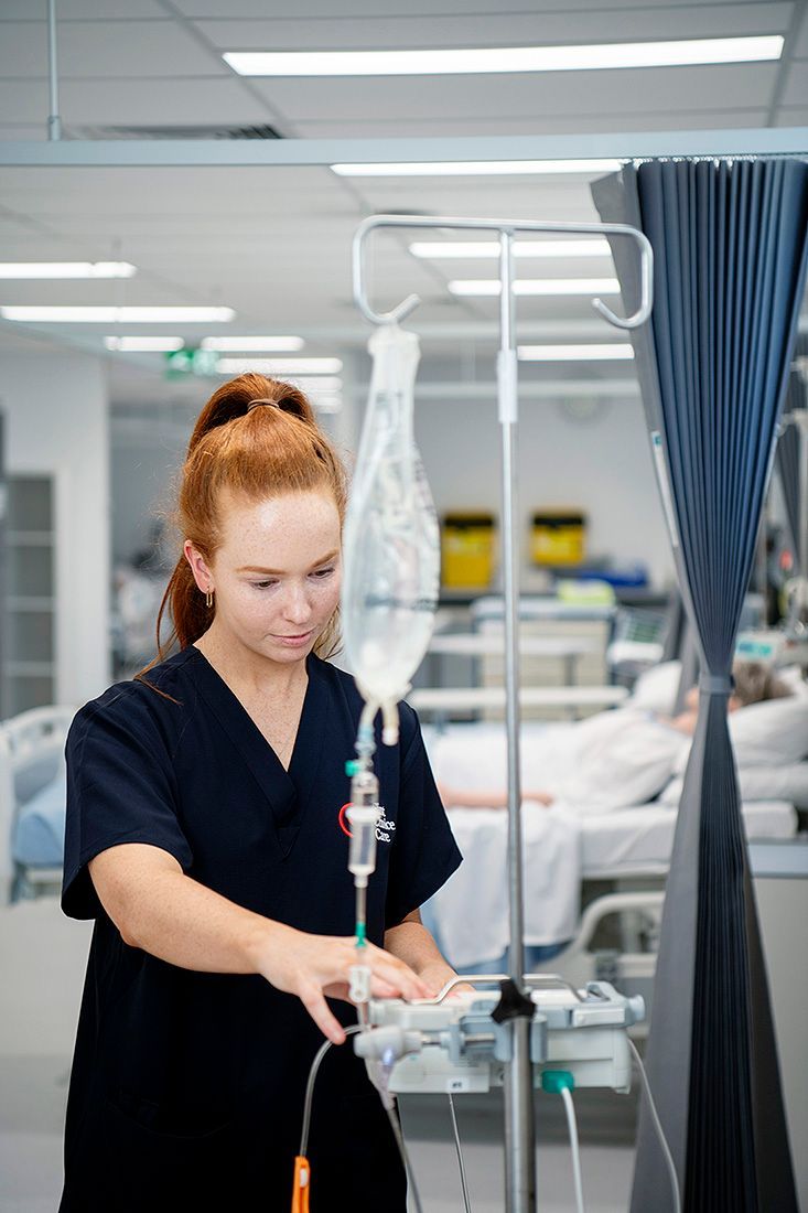 A surgeon is talking to another surgeon in a hospital room.