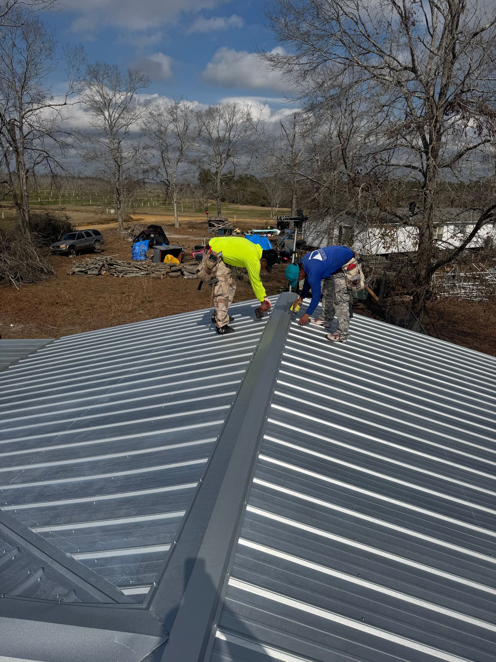A group of men are working on a metal roof.