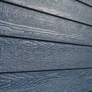 A close up of a blue wooden siding on a house.