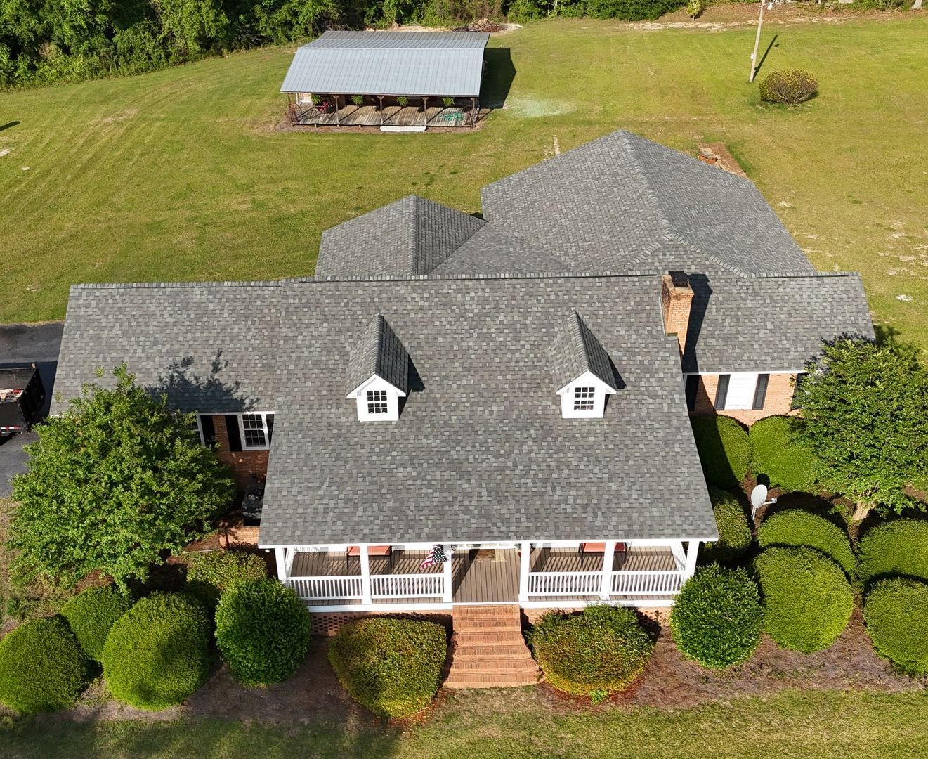 An aerial view of a large house with a gray roof