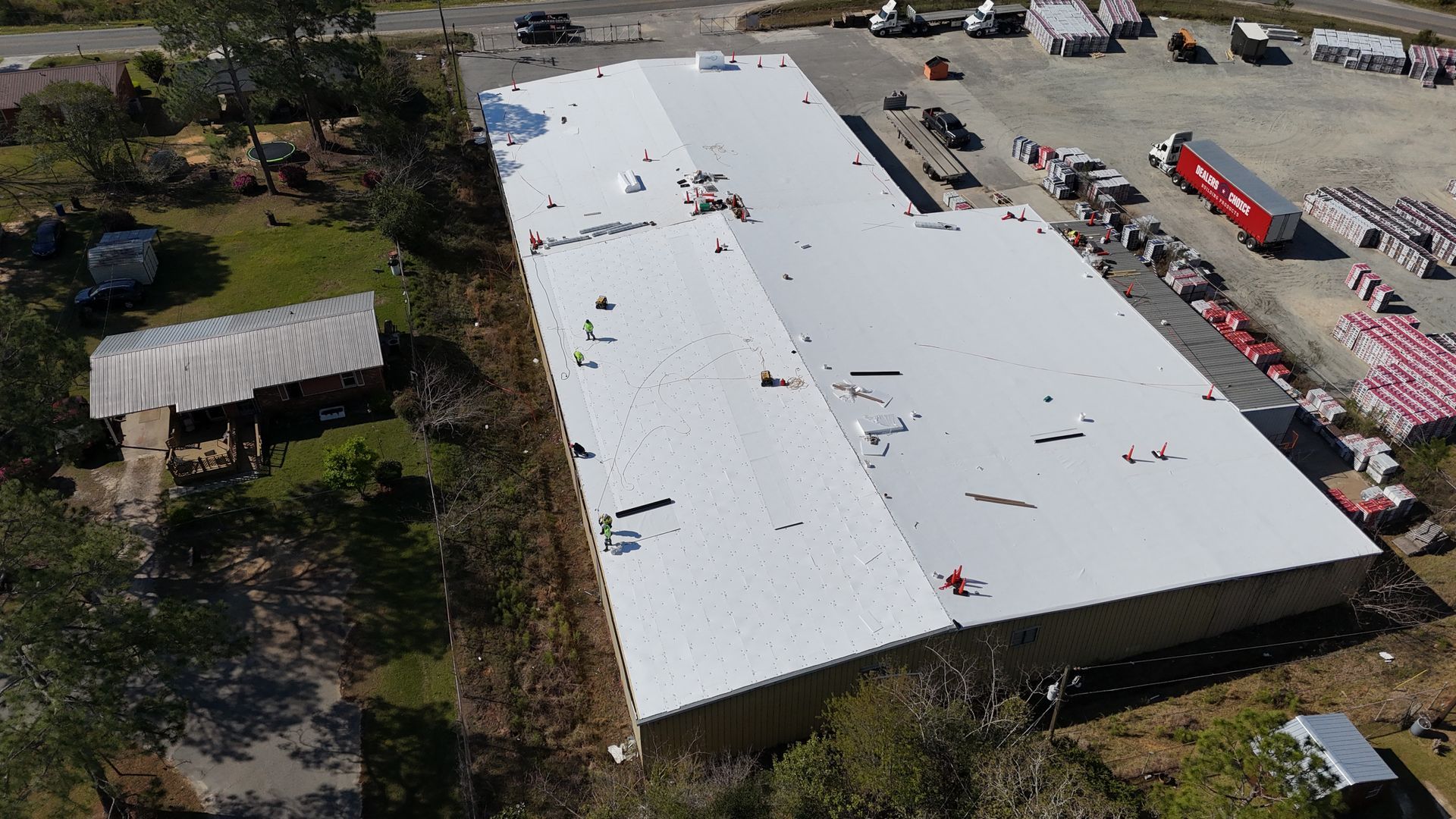 An aerial view of a large building with a white roof.