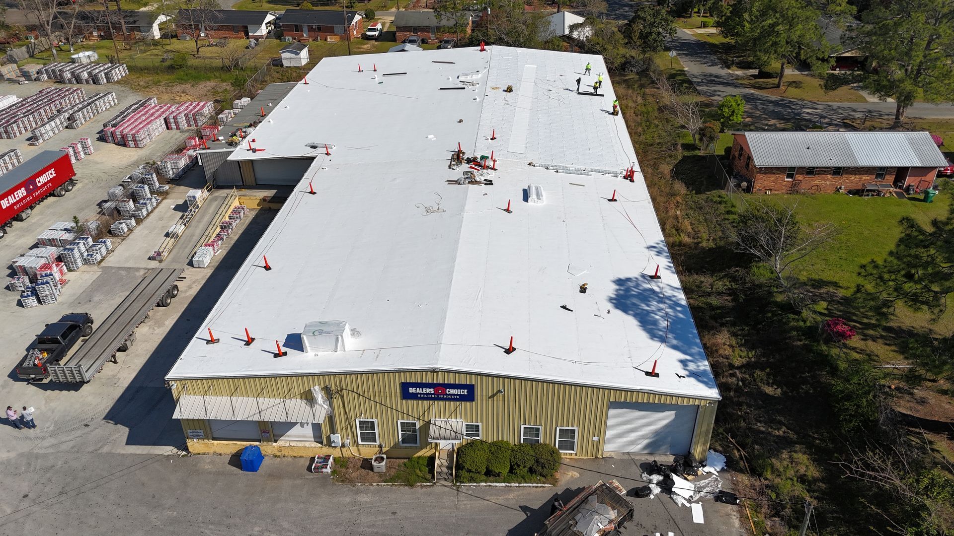 An aerial view of a large building with a white roof