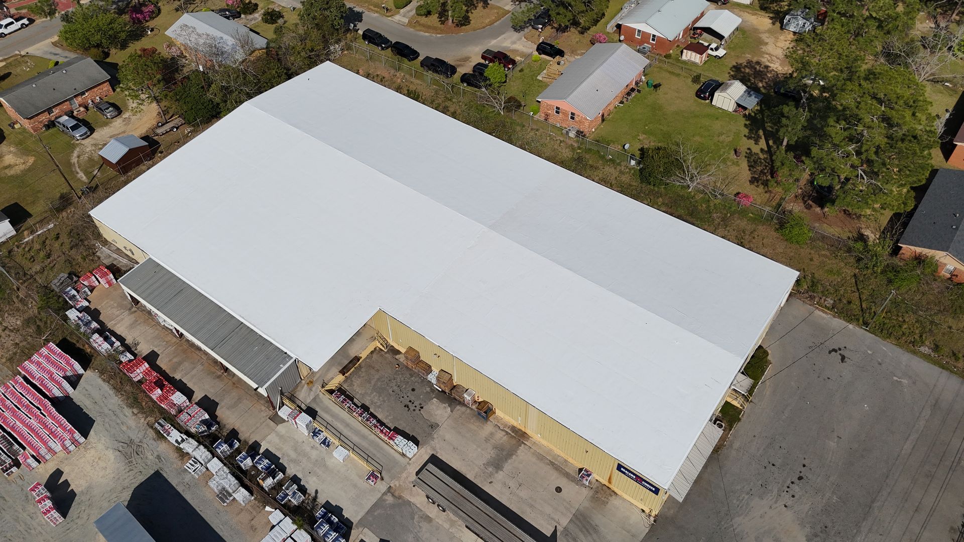 An aerial view of a large building with a white roof
