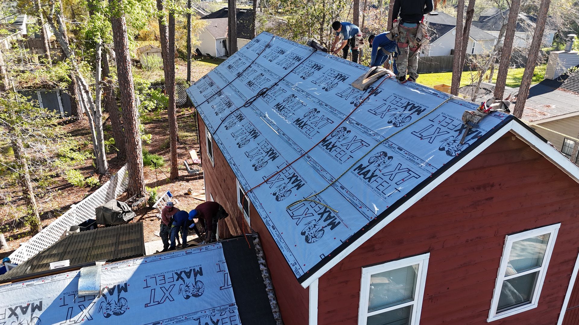 A group of people are working on the roof of a house.