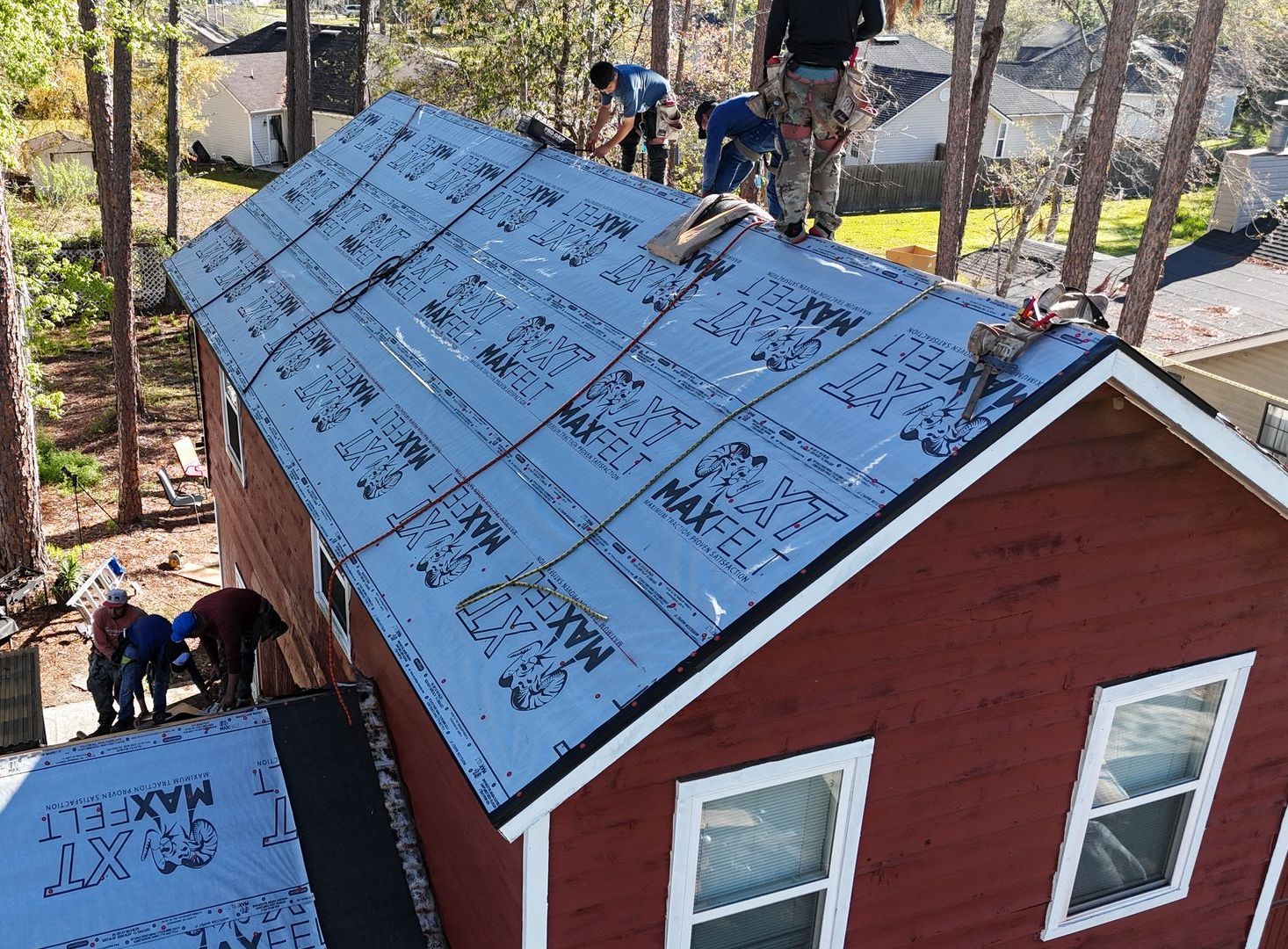 A group of men are working on the roof of a house.
