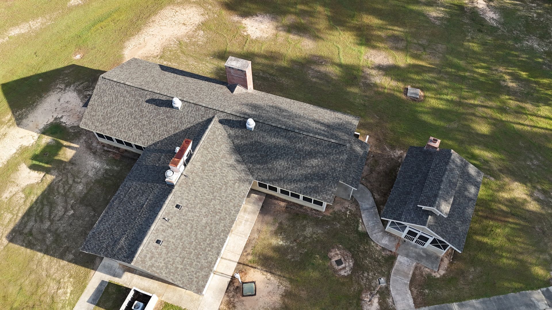 An aerial view of a house with a roof that is covered in shingles.