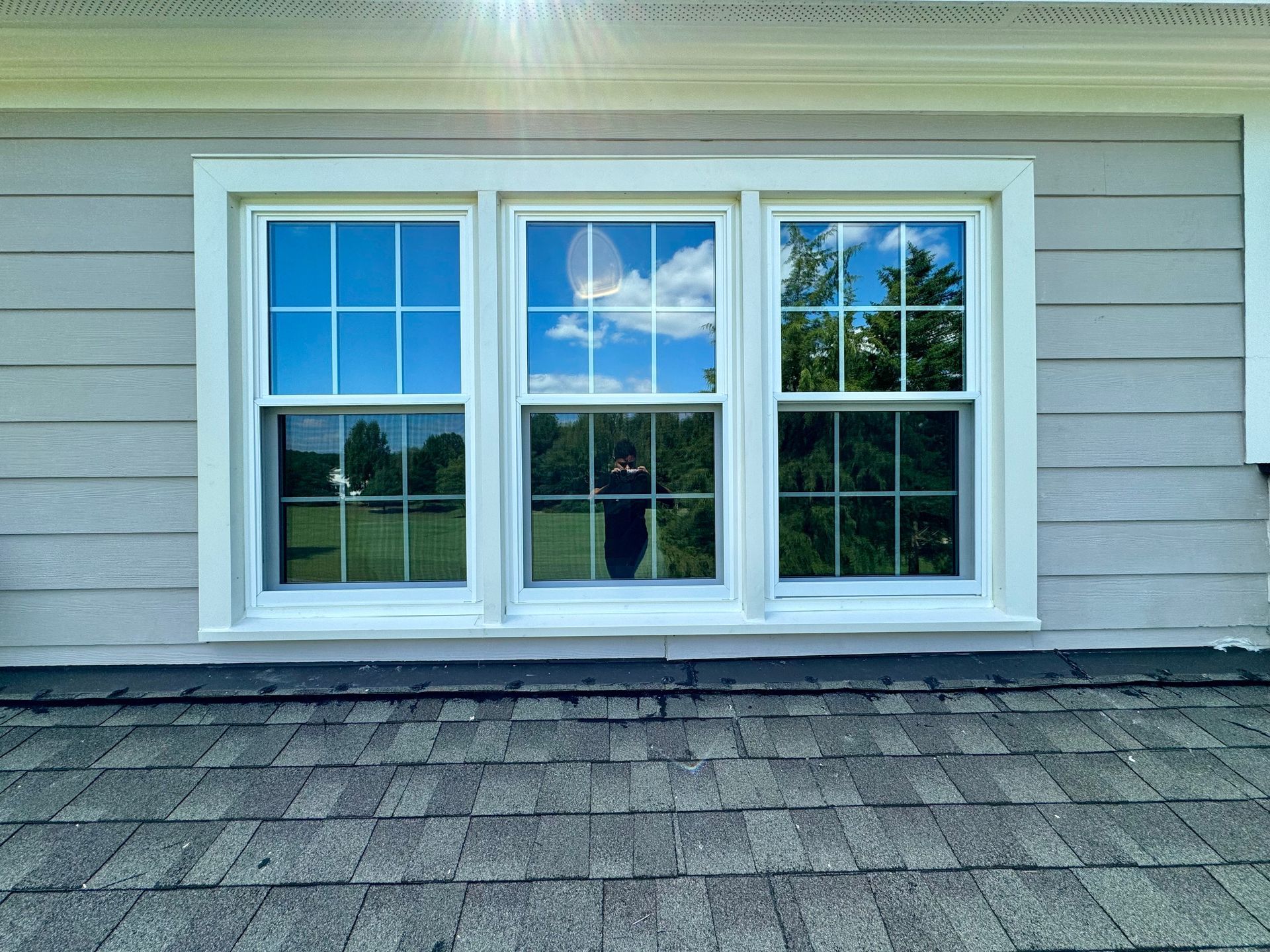 There are three windows on the side of a house.