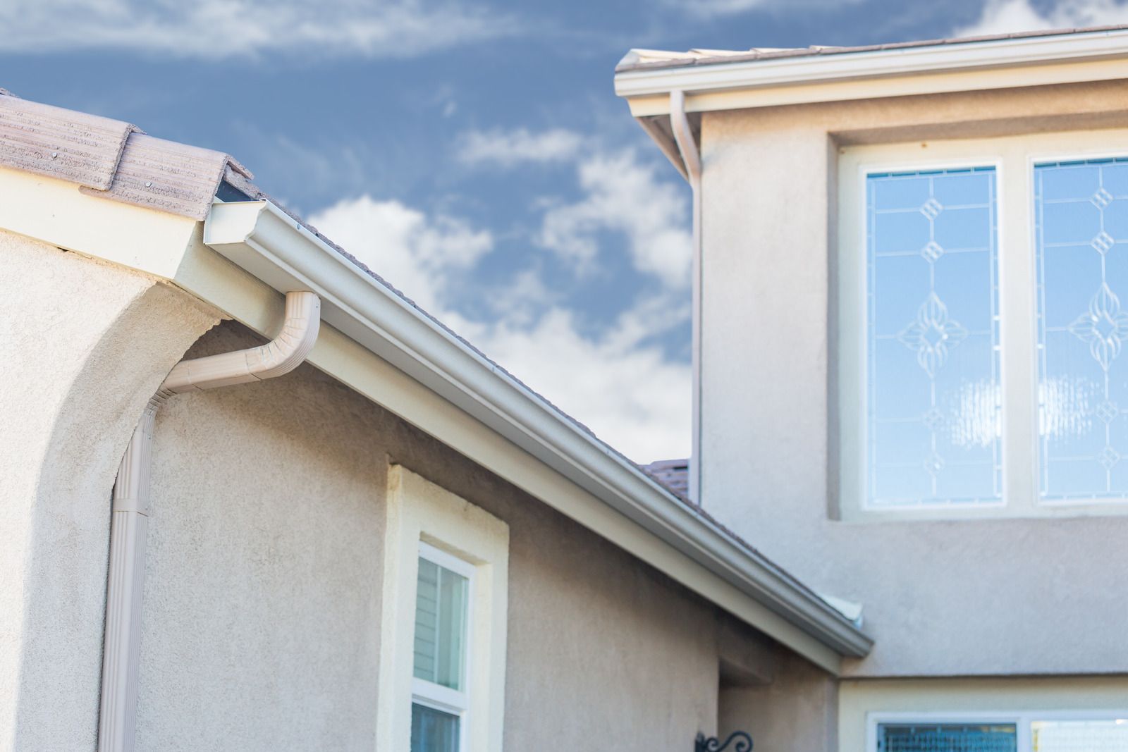 A house with a gutter on the side of it and a window.