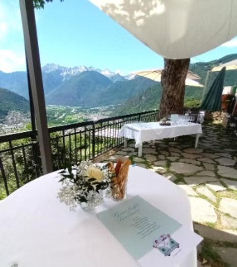 Tavolo apparecchiato per l'evento con vista sulle montagne sullo sfondo.