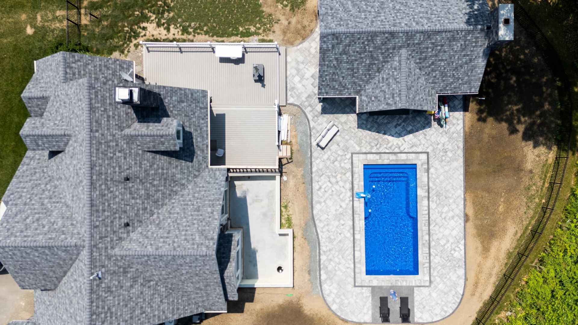 An aerial view of a house with a large pool in the backyard.