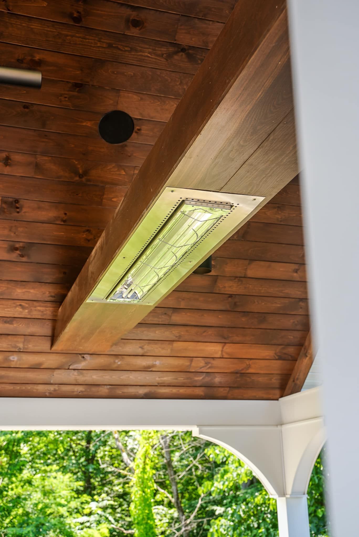 A wooden ceiling with a light hanging from it.