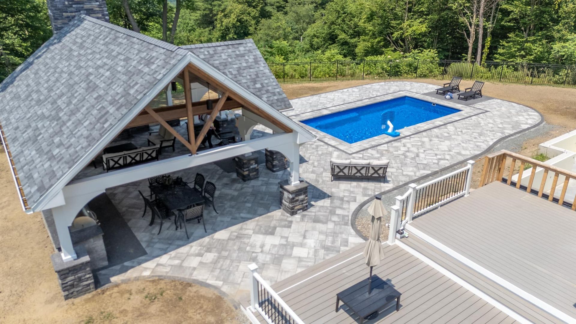An aerial view of a house with a large swimming pool in the backyard.