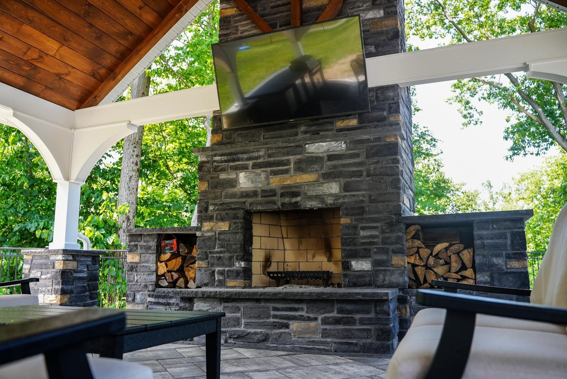 A stone fireplace with a flat screen tv above it.