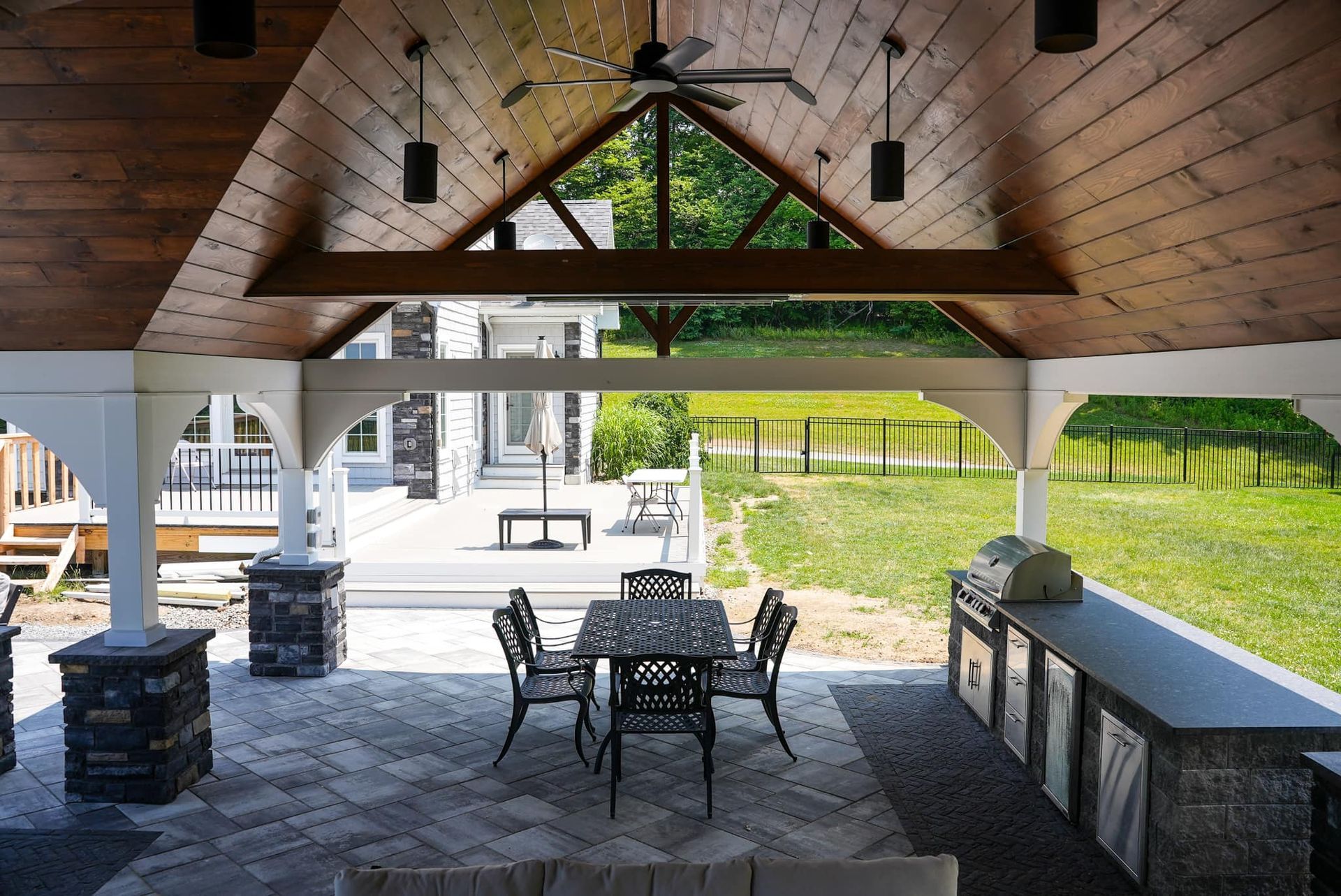 A patio with a table and chairs and a ceiling fan.