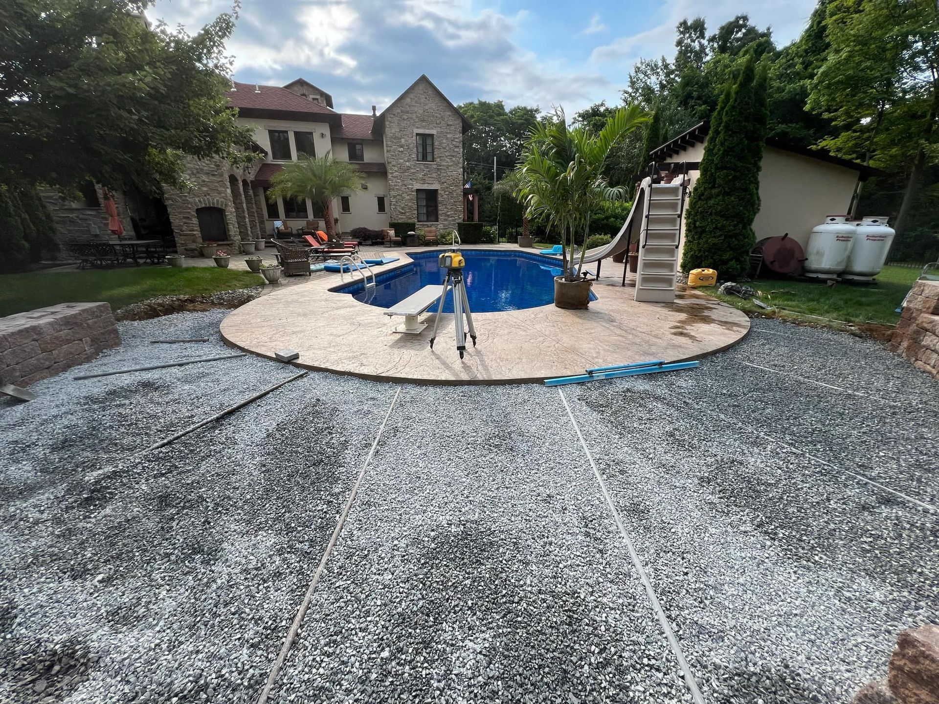A swimming pool is being built in the backyard of a house.
