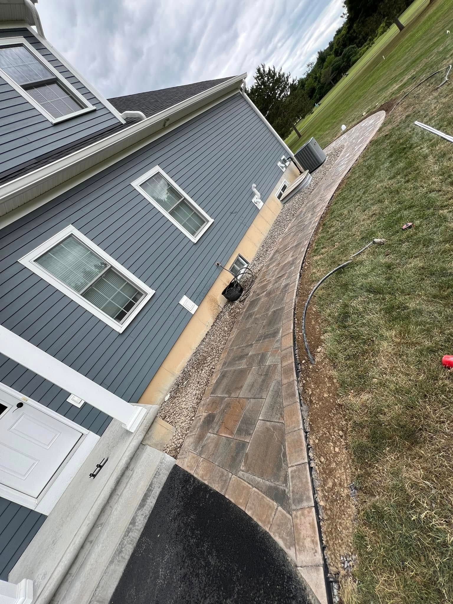 A sidewalk is being built in front of a house.