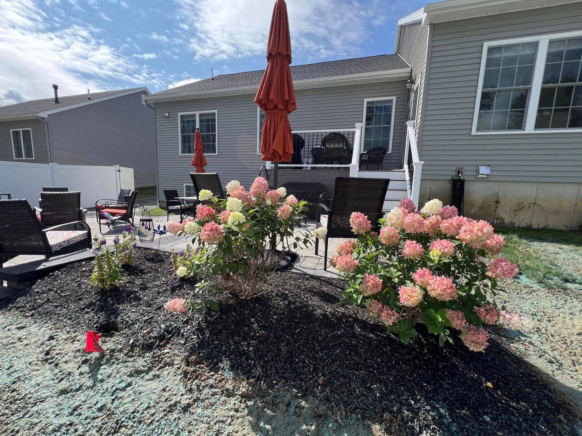 A house with a patio and flowers in front of it