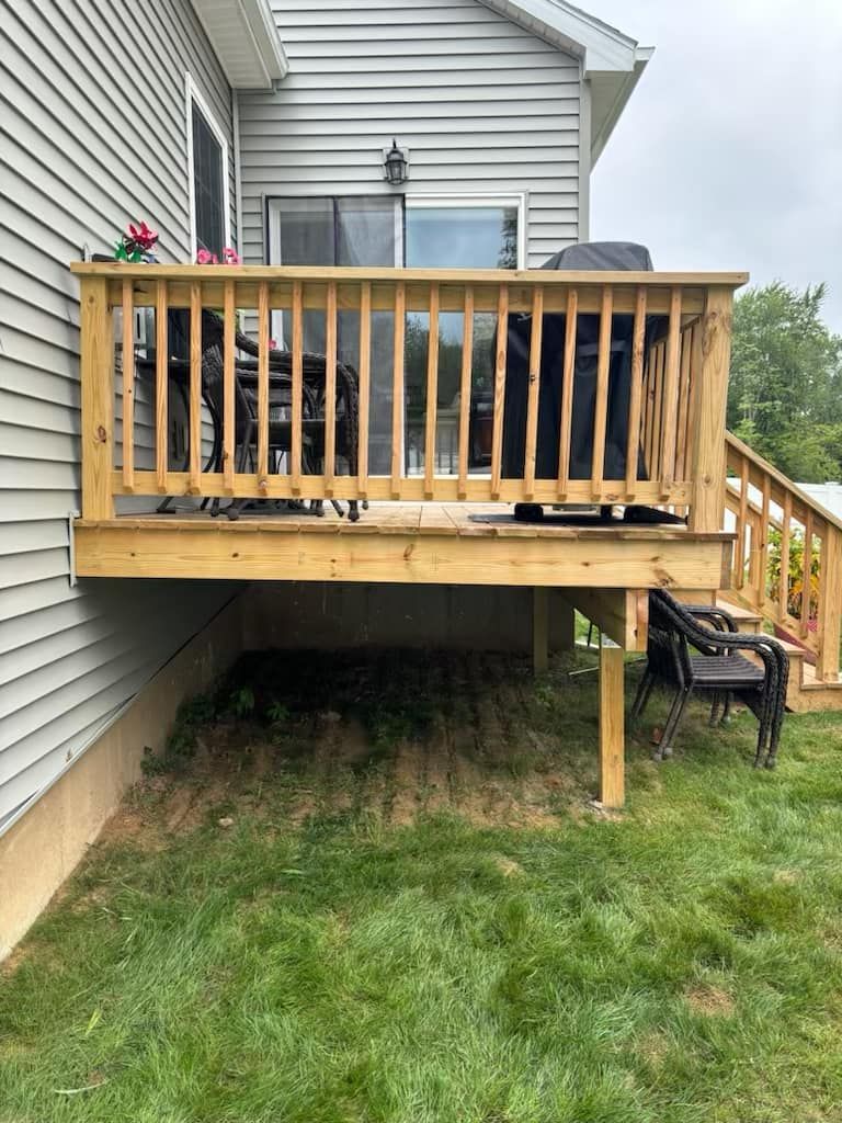 A wooden deck is attached to the side of a house.