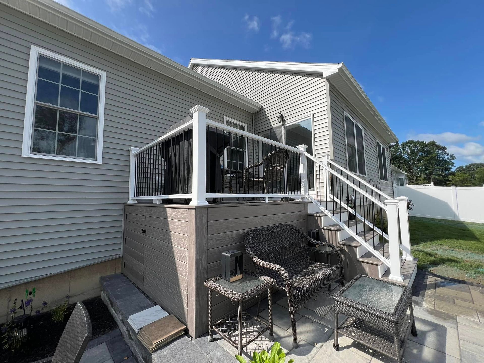 A mobile home with a large deck and stairs.