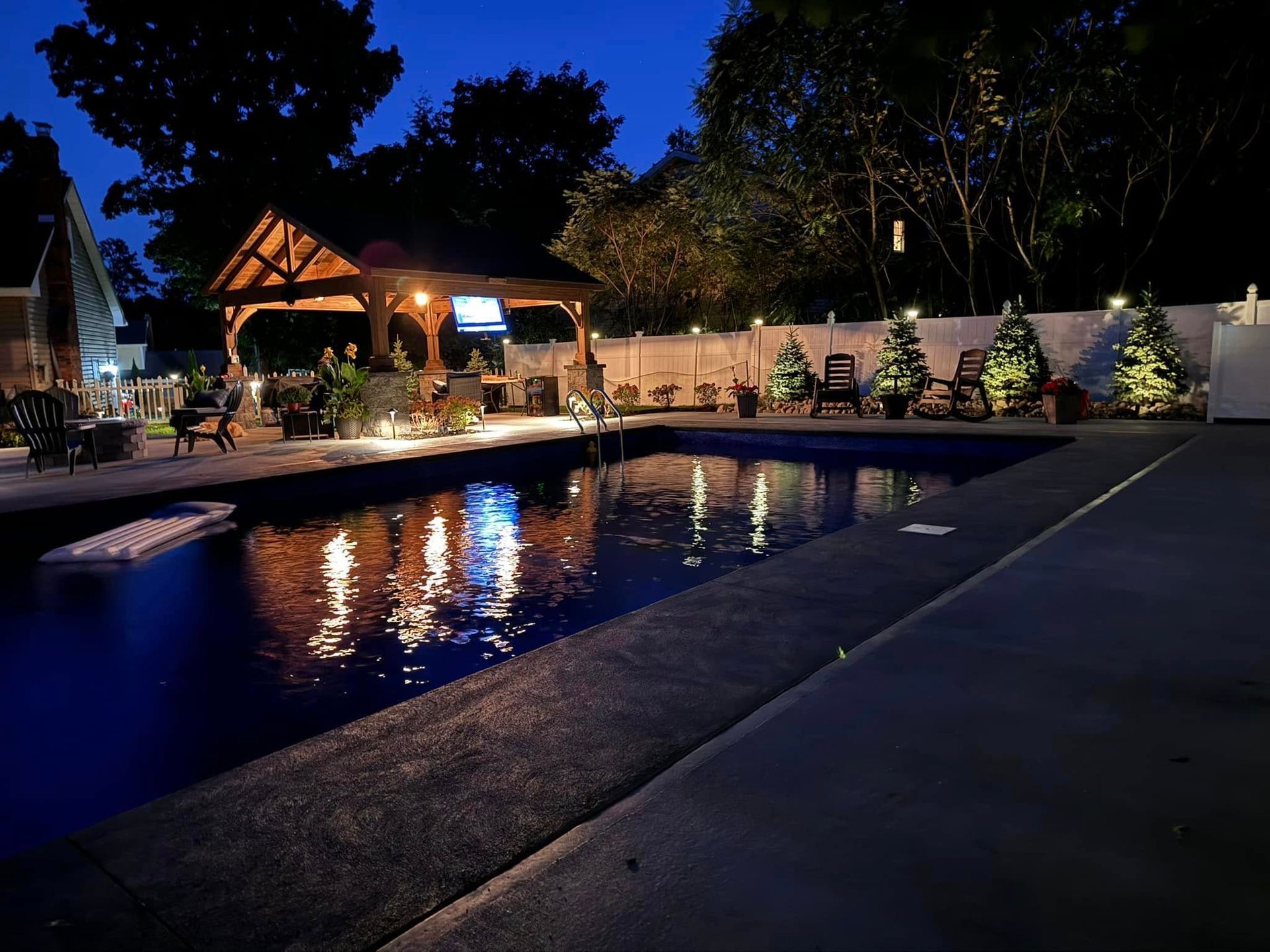 A large swimming pool is lit up at night