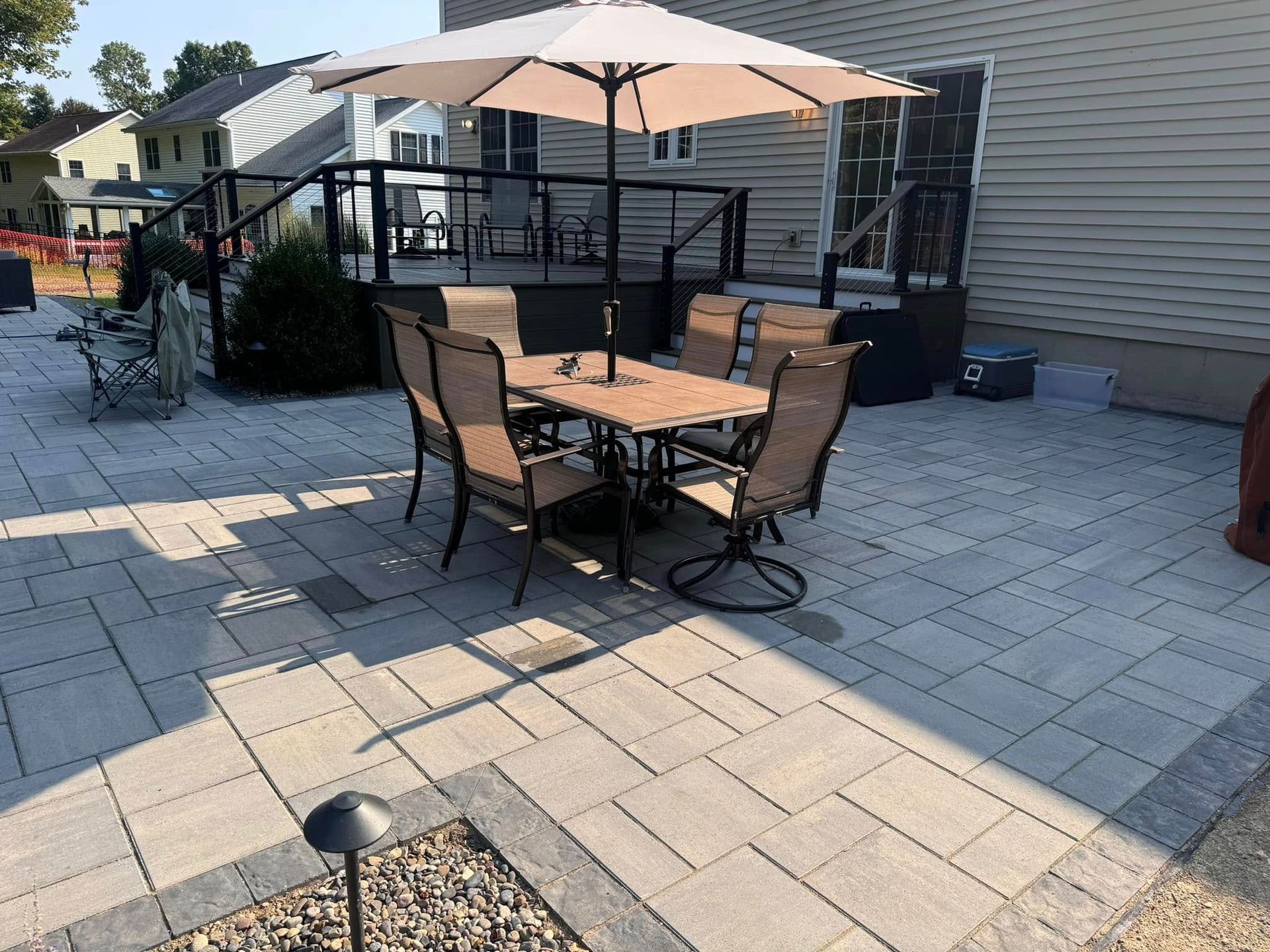 A patio with a table and chairs under an umbrella.