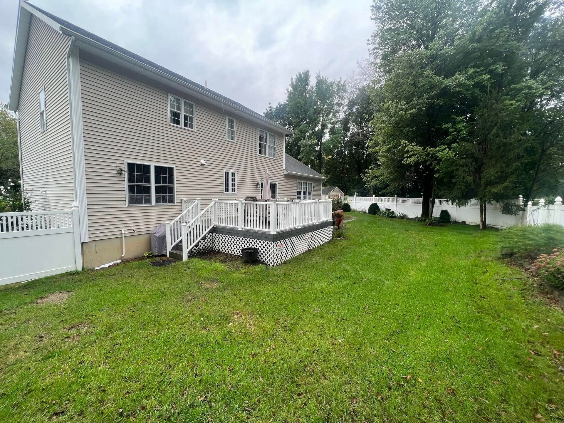A large house with a large deck in the backyard.