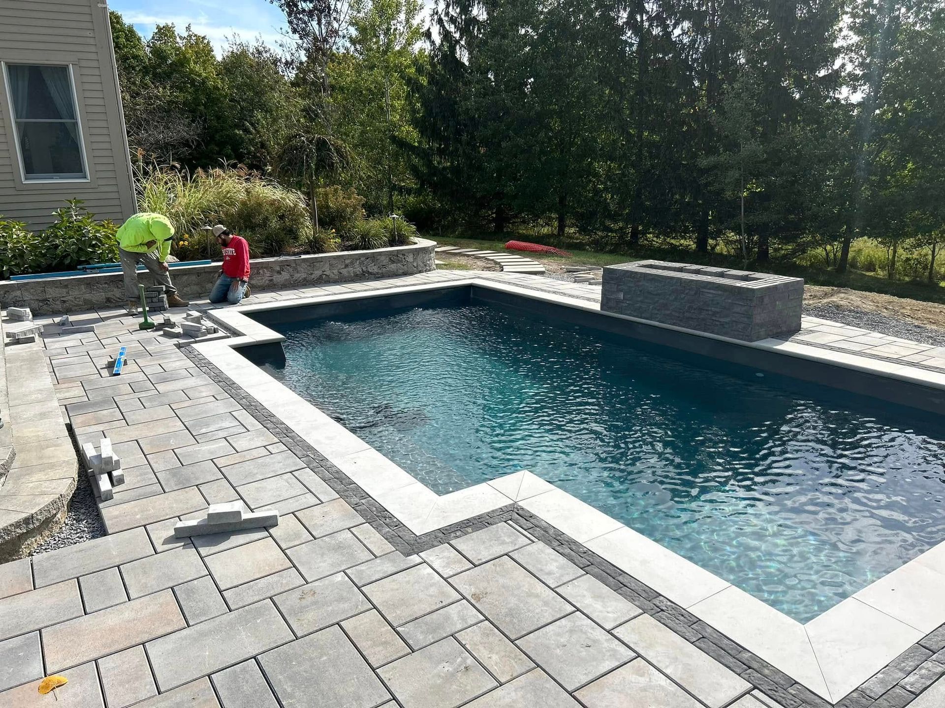 A large swimming pool is being built in a backyard