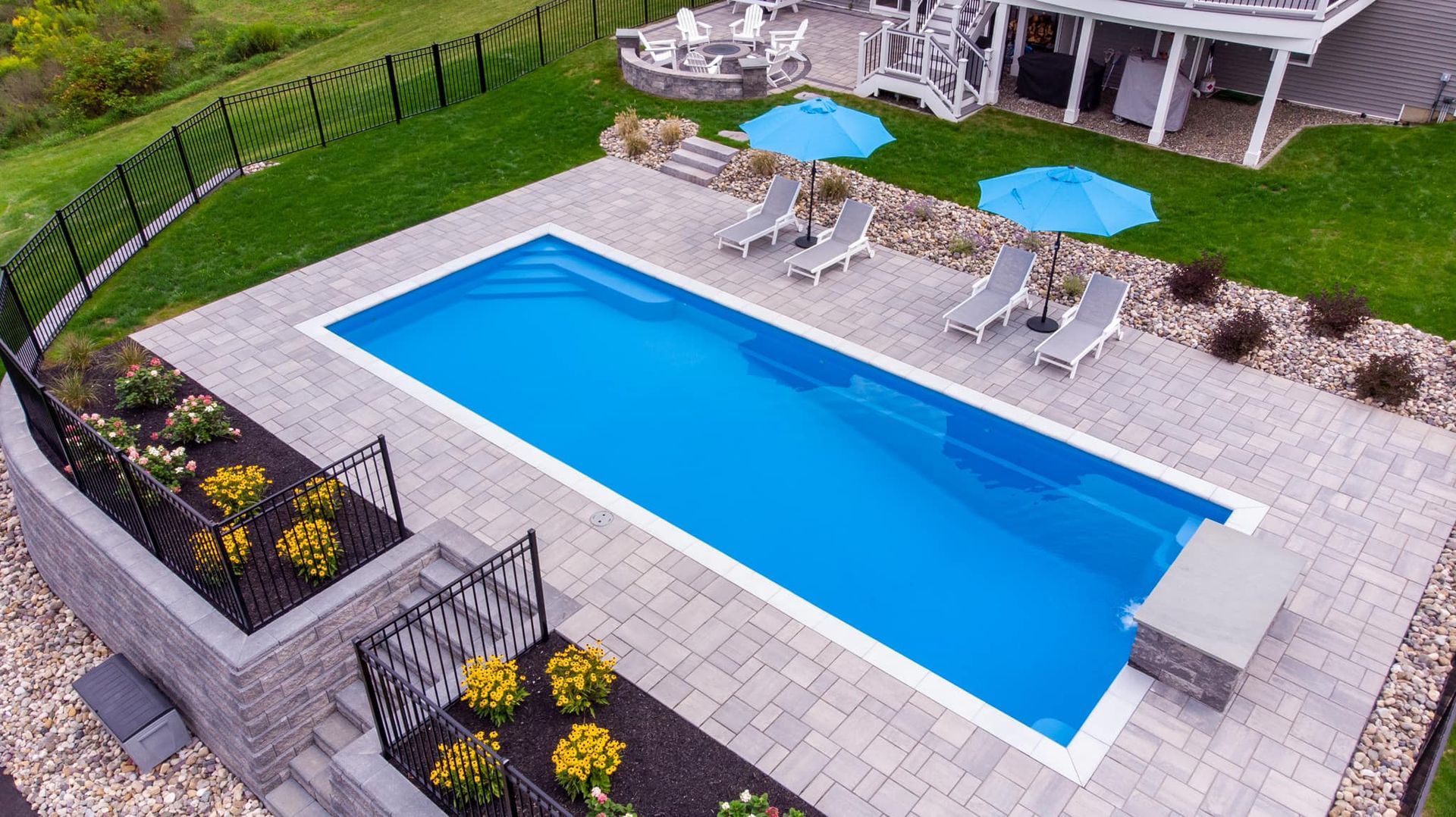 An aerial view of a large swimming pool surrounded by chairs and umbrellas.