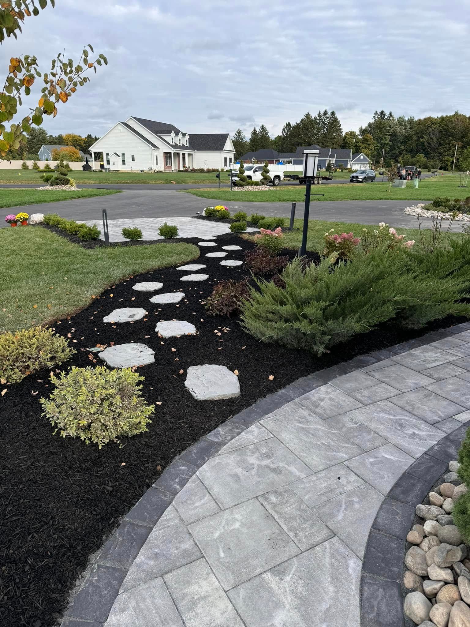 A walkway with stepping stones leading to a house in the background.