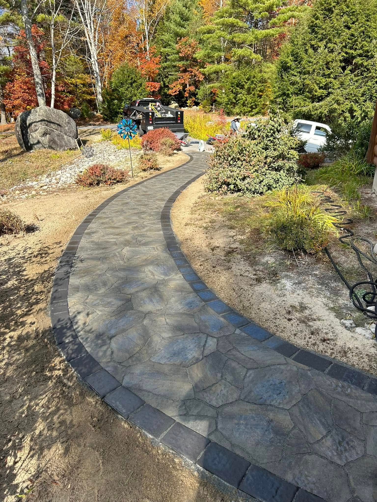 A curved walkway in a garden surrounded by trees and bushes.