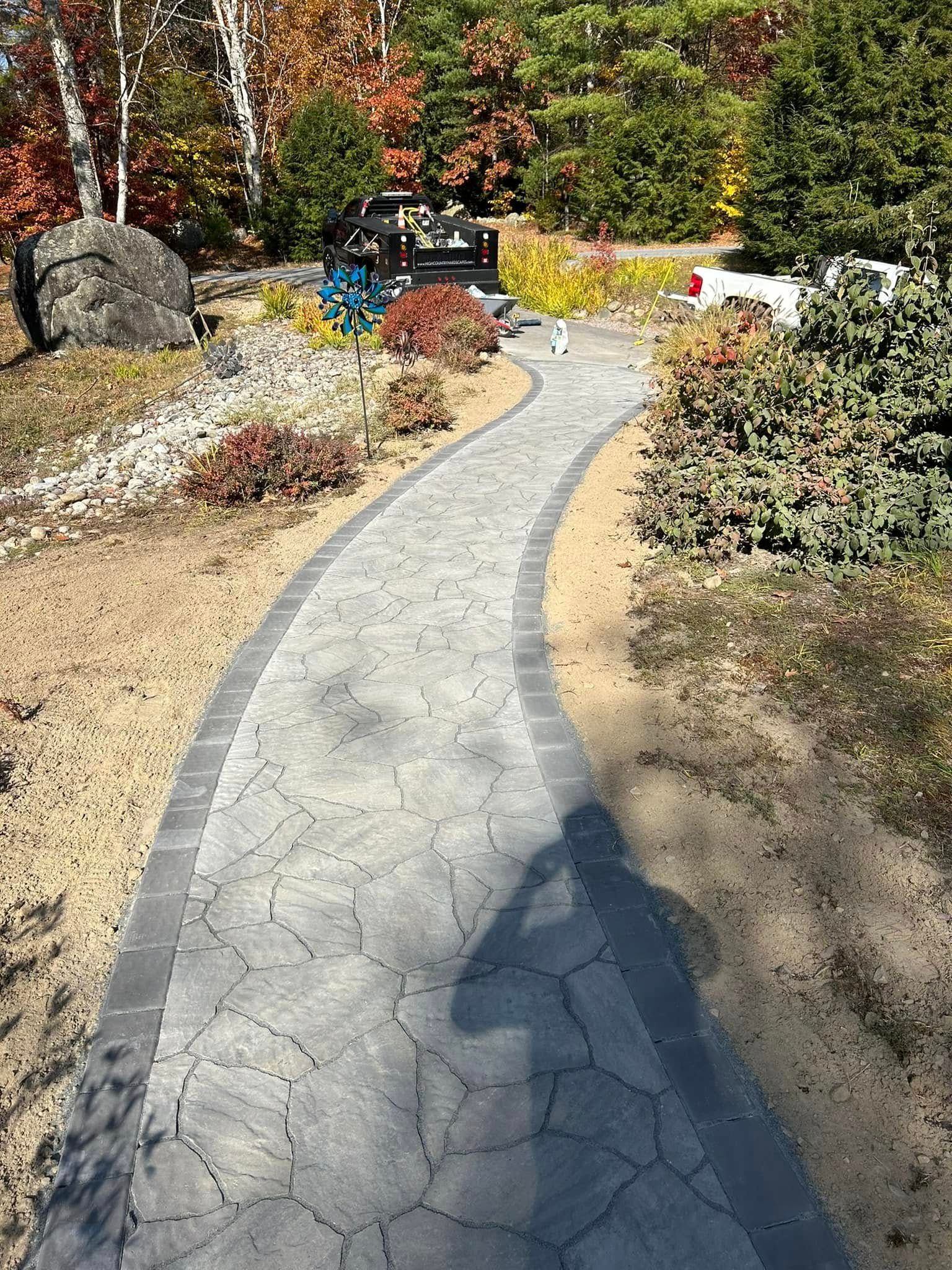 A shadow of a person is cast on a concrete walkway.