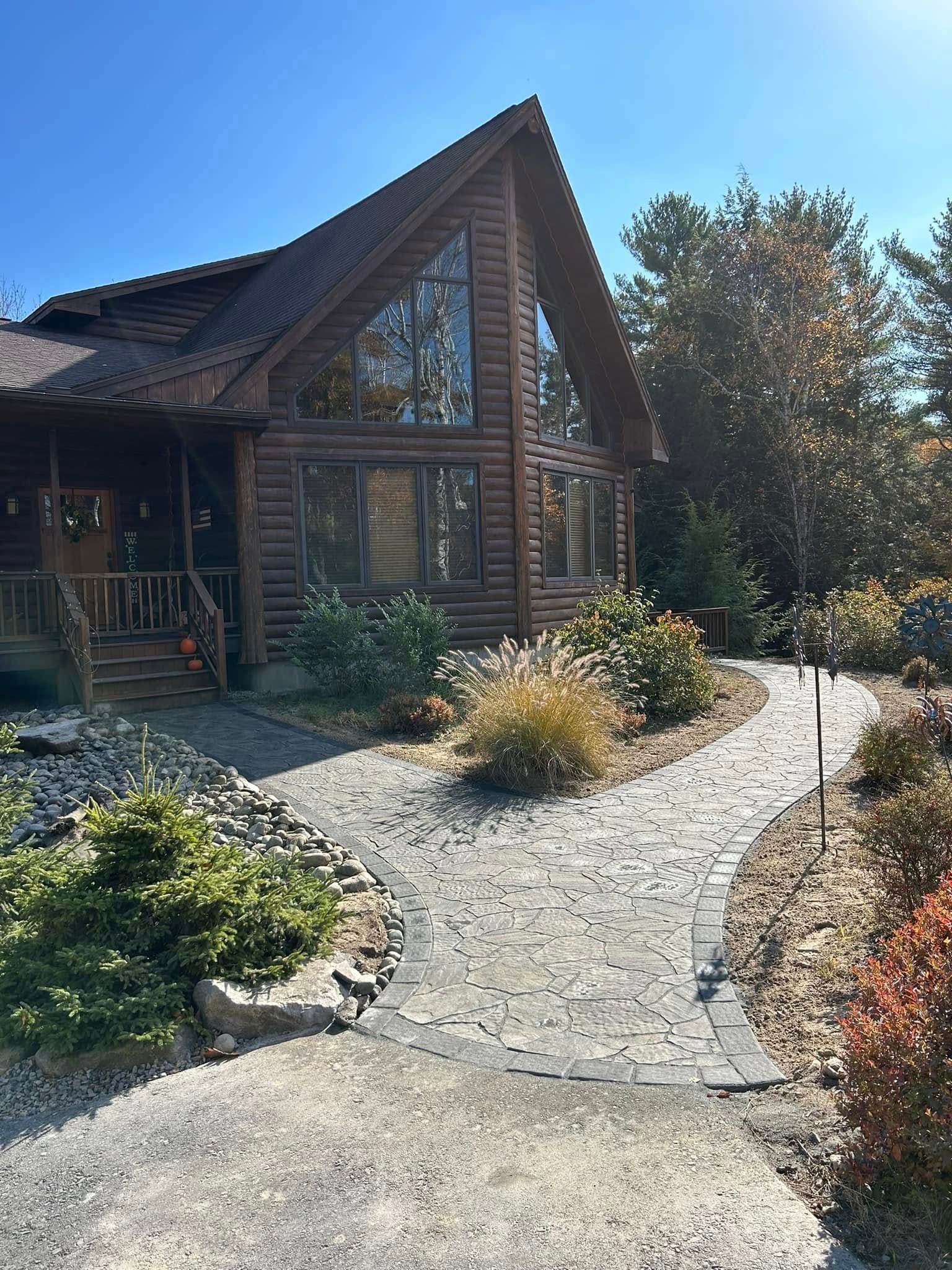 A large log cabin with a walkway leading to it.