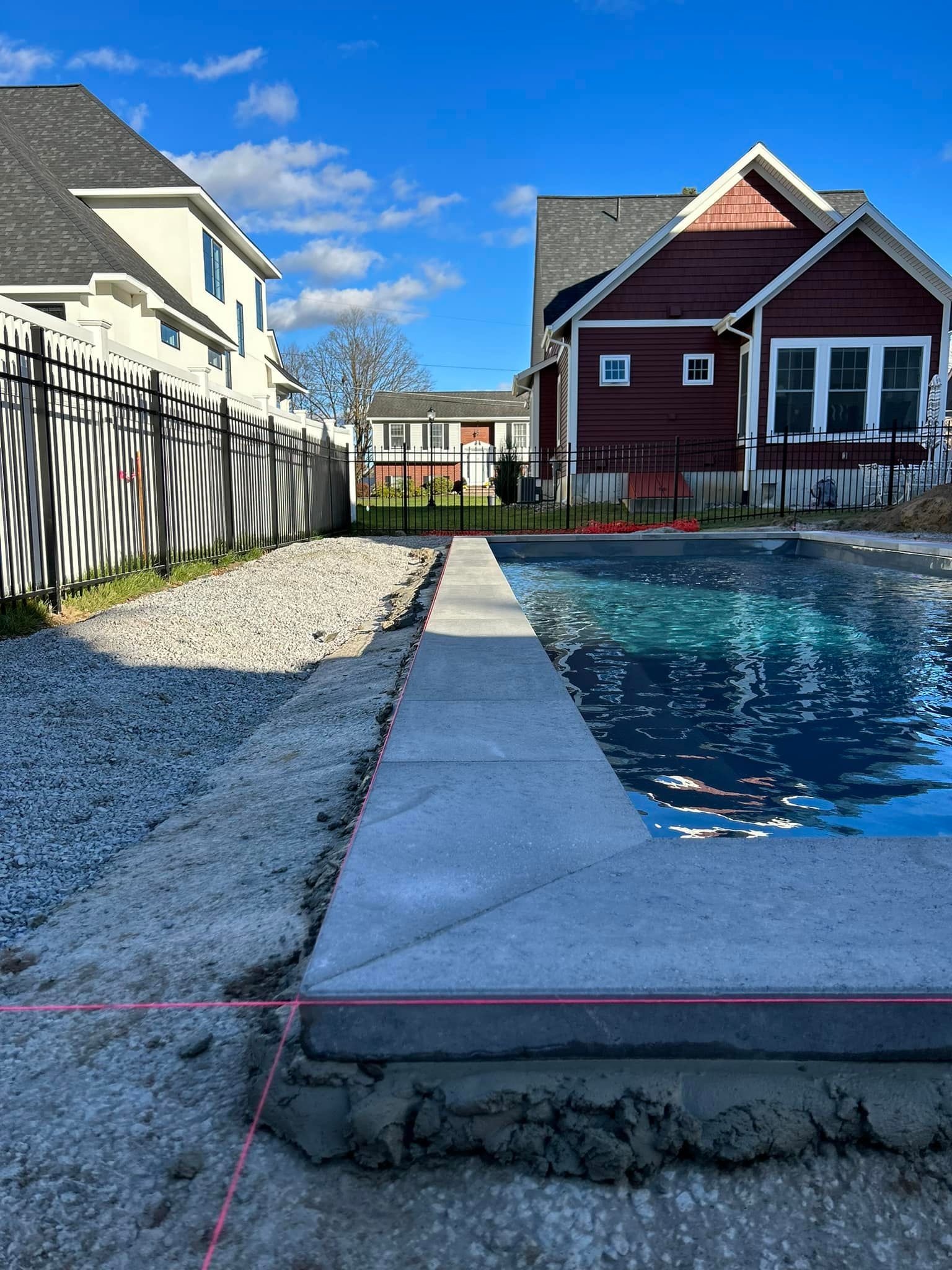 A swimming pool is being built in the backyard of a house.