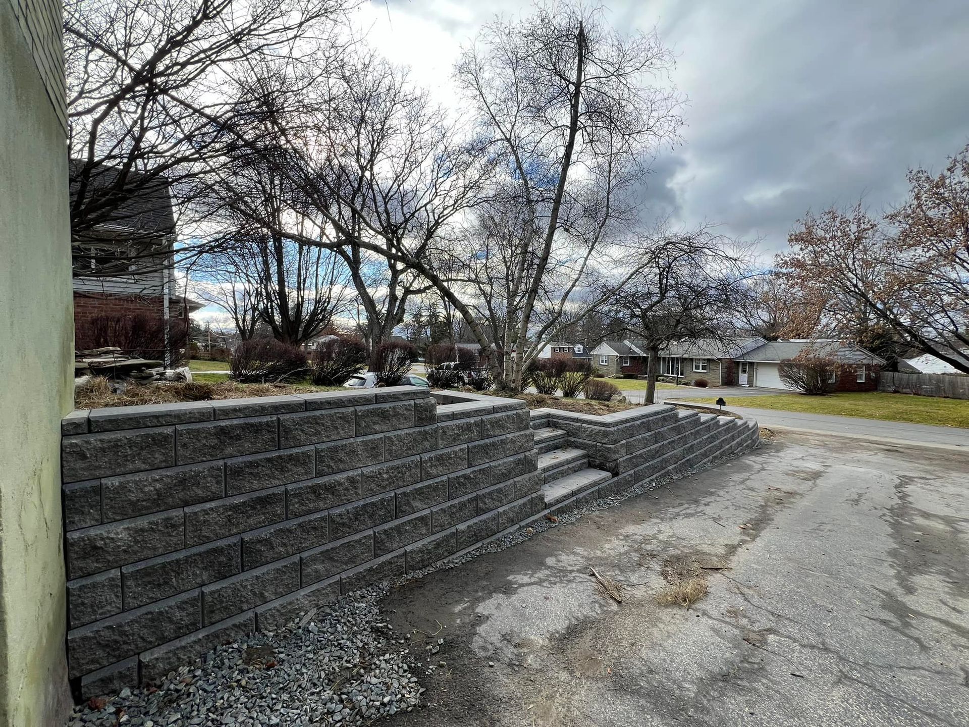 A brick wall is being built in front of a house.