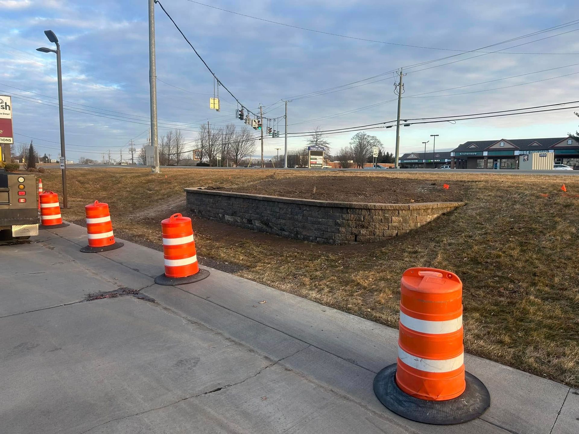 A row of orange and white traffic cones on a sidewalk.