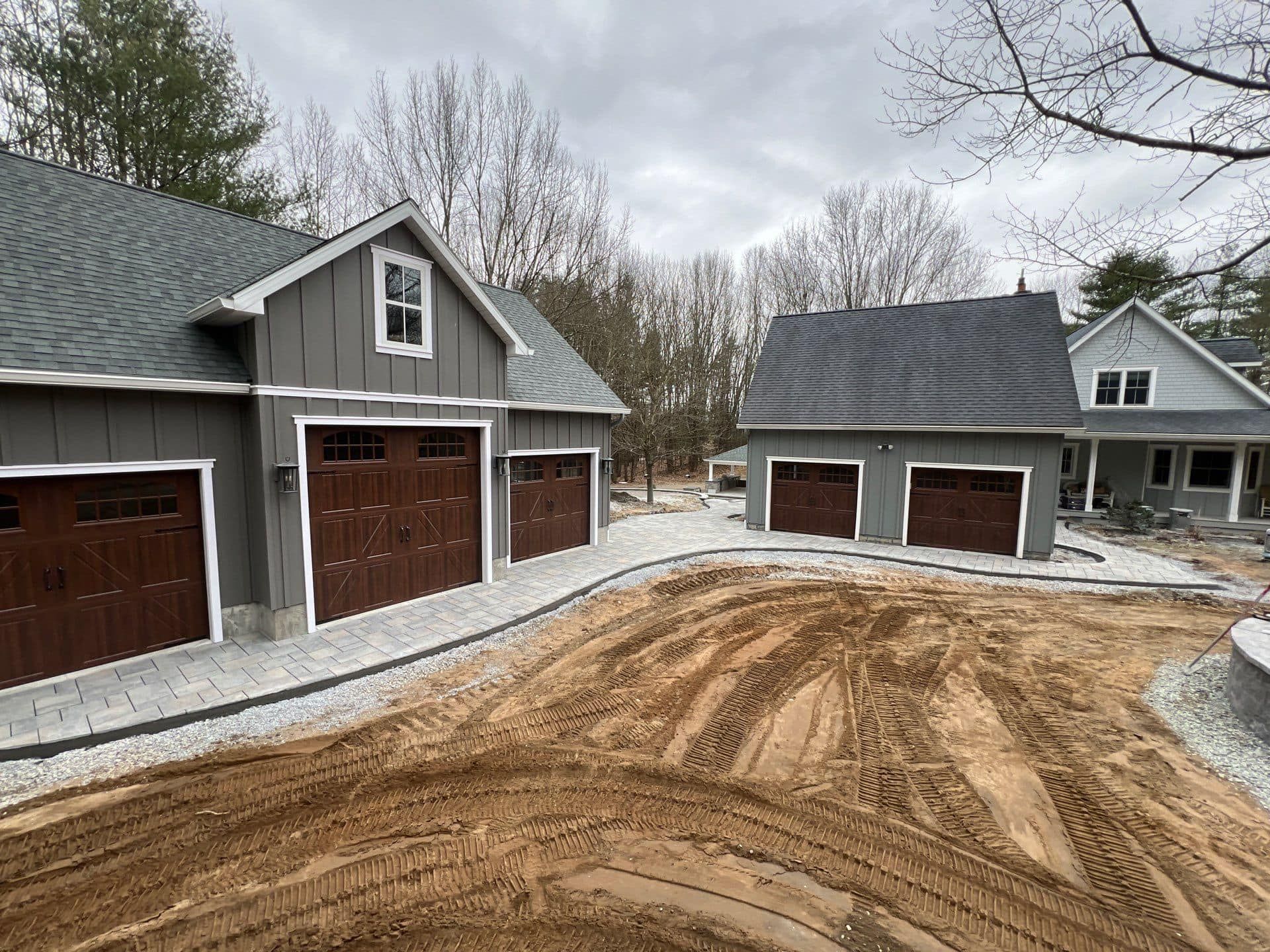 A couple of garages next to each other on a dirt road.