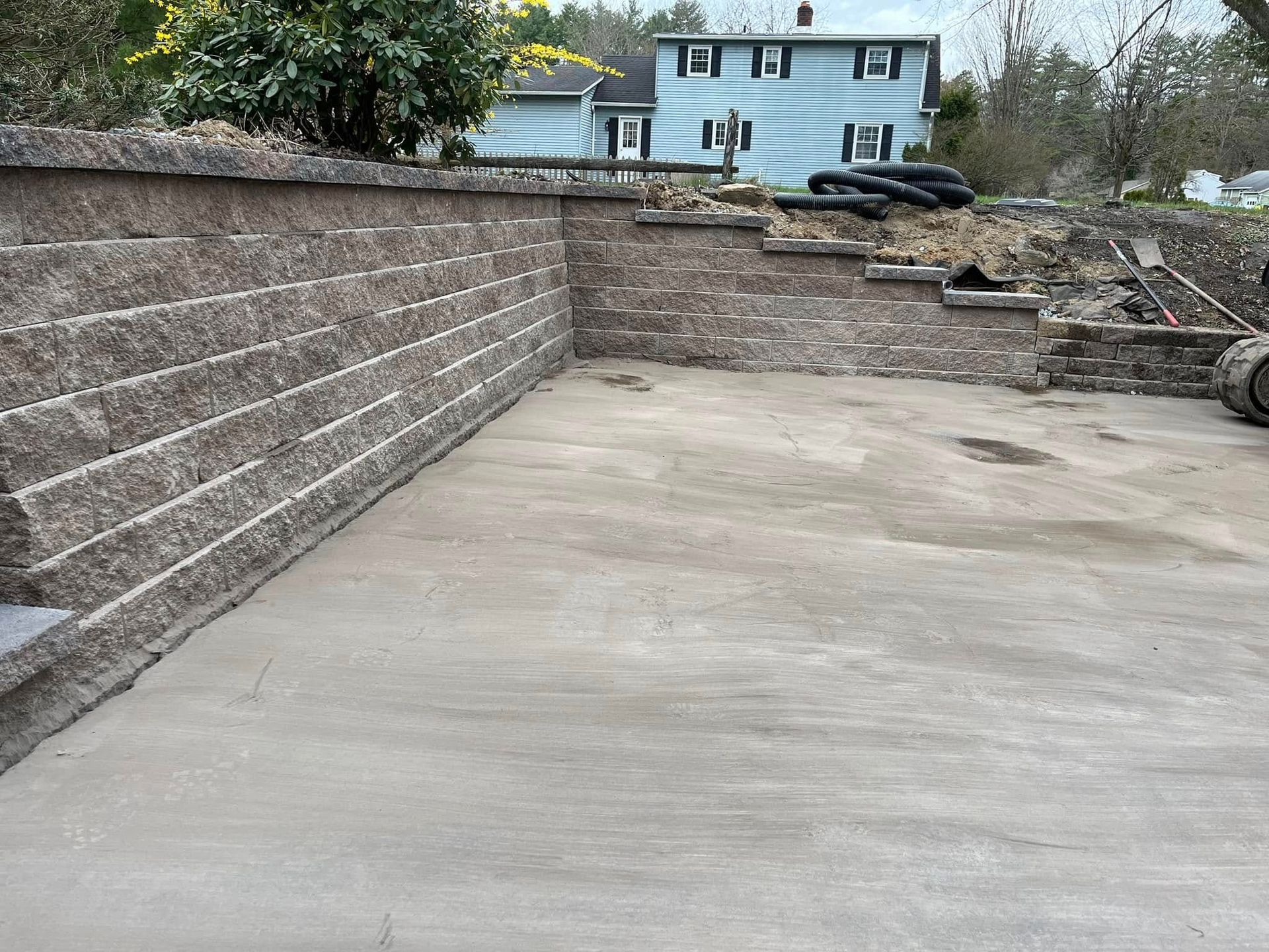 A brick wall is being built in front of a house.