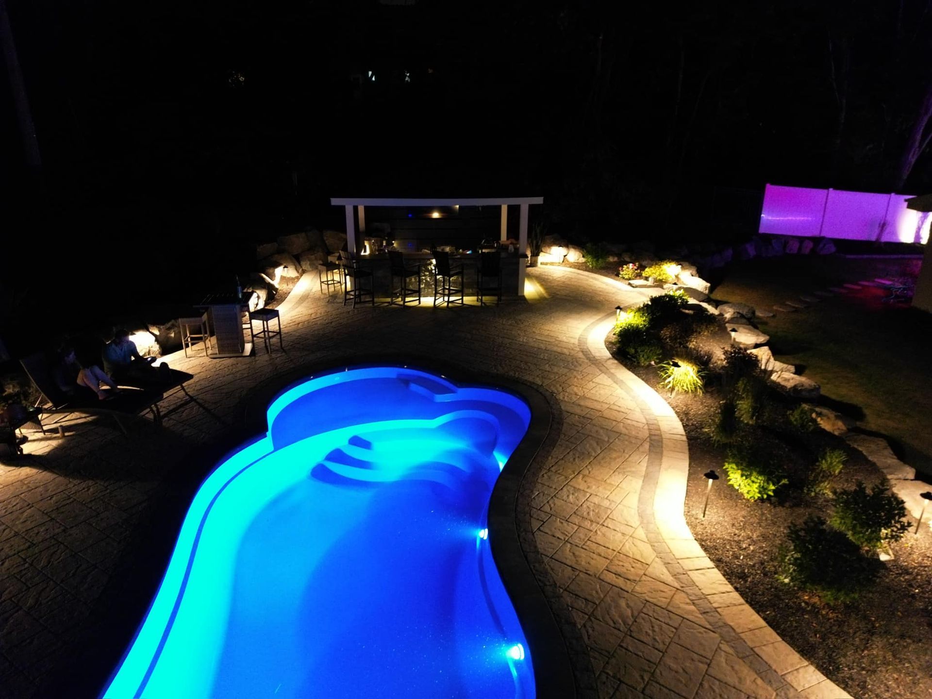 An aerial view of a swimming pool lit up at night